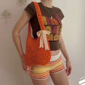 Handmade orange crochet straw bag with cream lace bow